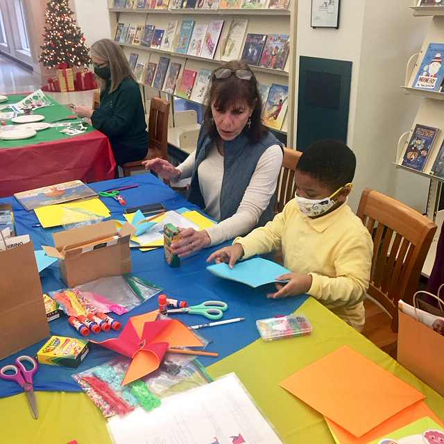 Marcia Line helps a kid with crafts