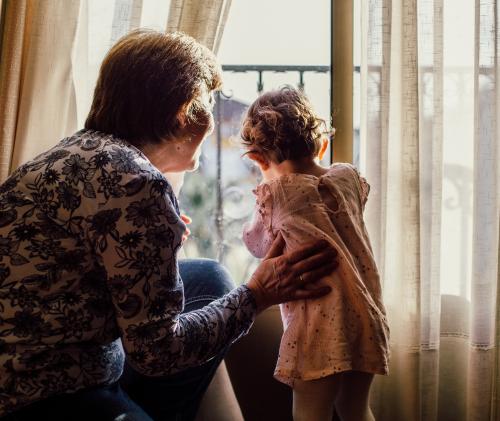 Grandmother and granddaughter looking out a window