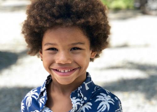 Young boy standing in a street smiling