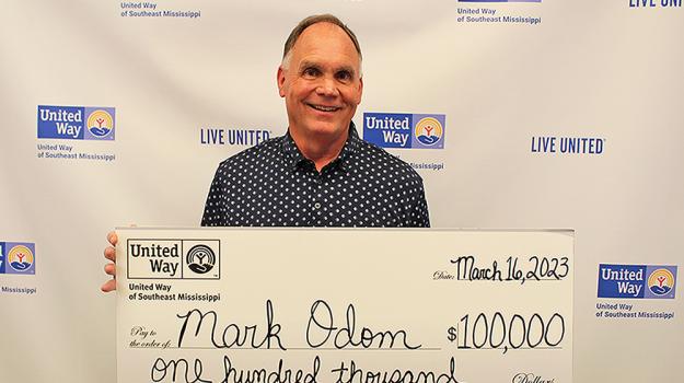 2023 United Way Payday Winner Mark Odom holding a large $100,000 check