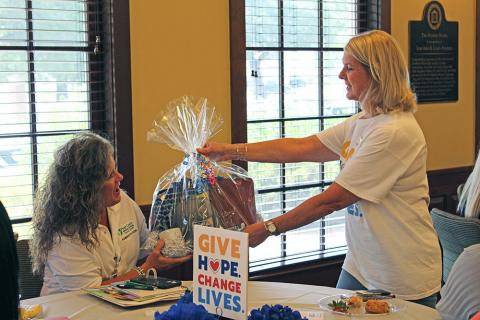 Tracie Fowler, United Way of Southeast Mississippi CEO, presents Regina Arnold, with Forrest General a door prize during the 2022-23 United Way Campaign Pacesetter Kick-Off July 12 at USM's Ogletree Alumni House.